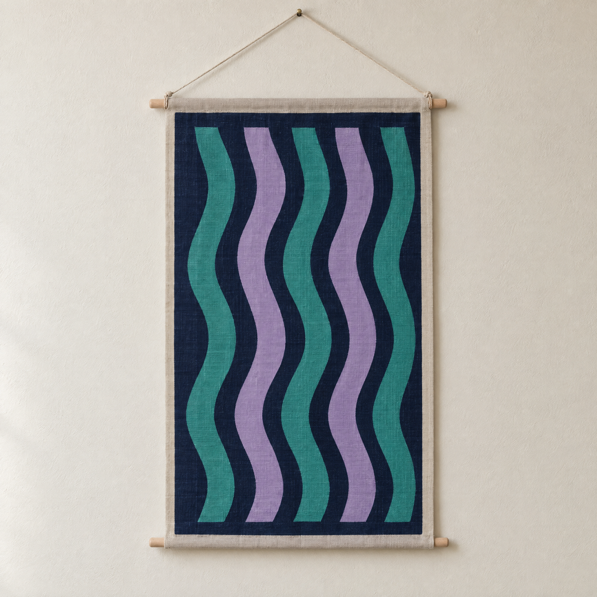 Aurora screen-printed canvas wall hanging on beech dowels, hung on a plain wall
