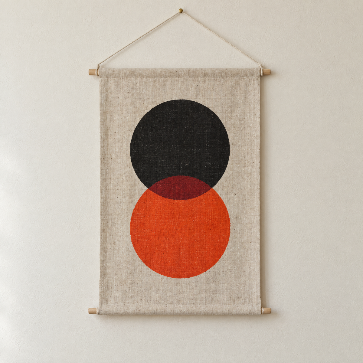 Eclipse screen-printed canvas wall hanging on beech dowels, hung on a plain wall