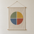 Four Seasons screen-printed canvas wall hanging on beech dowels, hung on a plain wall