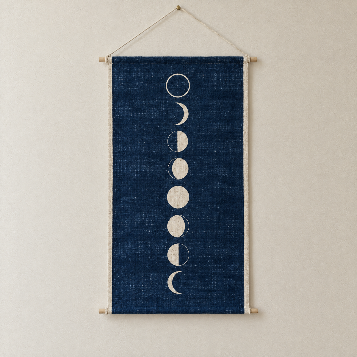 Moon Phases screen-printed canvas wall hanging on beech dowels, hung on a plain wall