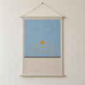 Sun Path screen-printed canvas wall hanging on beech dowels, hung on a plain wall